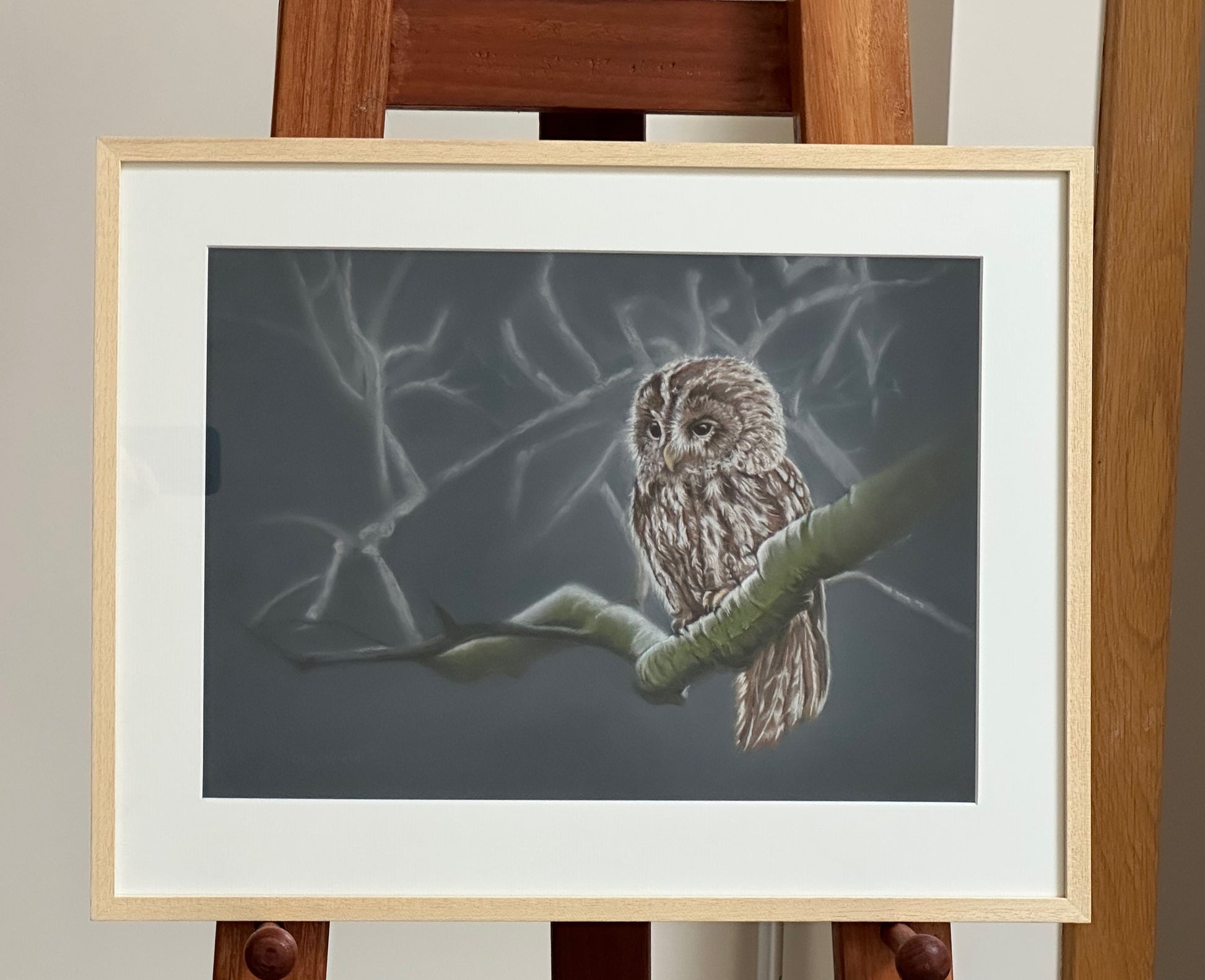 Framed artwork of an owl on a branch against a dark background